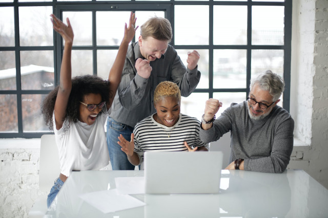 excited-multiracial-colleagues-enjoying-triumph-together-in-3931634